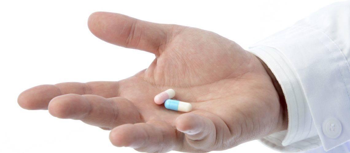 Hand of doctor holding capsules