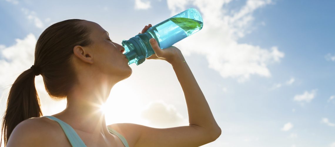 Female drinking a fresh water from bottle.